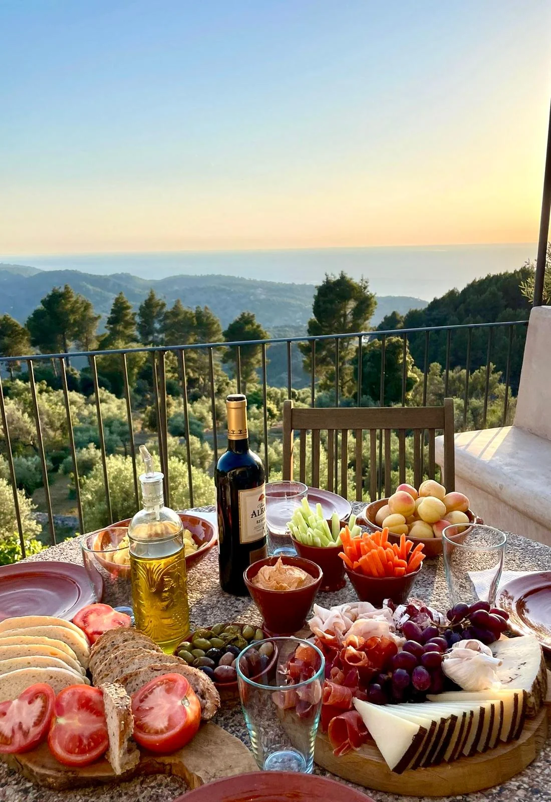 Mediterranean table with olive oil, bread, cheese, fruit and local products overlooking the sea